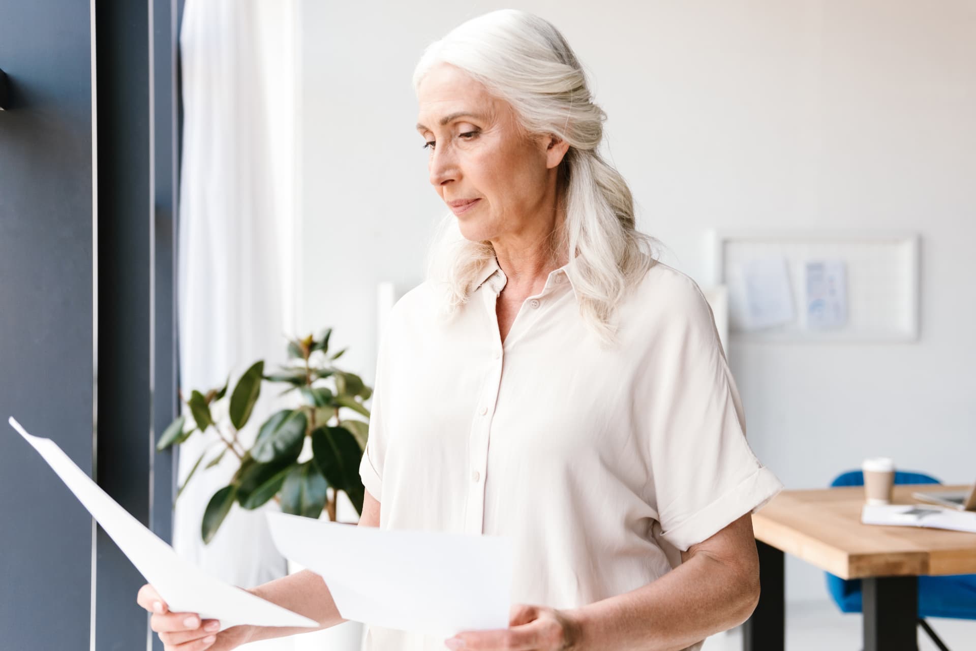 A woman quietly reviewing her care papers by a bright window