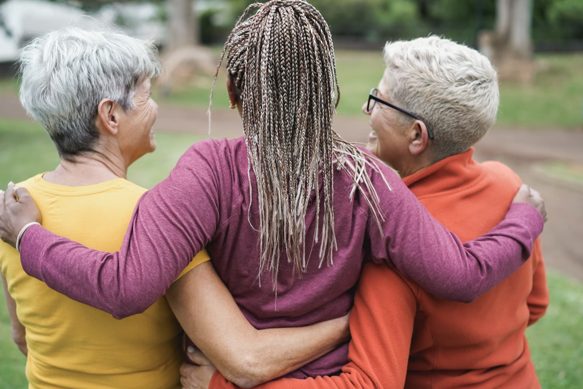 Three women with arms around each other in a Wise Woman Yoga circle